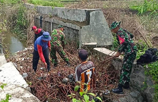 Babinsa Desa Nglegok Bahu Membahu Kerja Bakti dalam Bersihkan Irigasi Persawahan